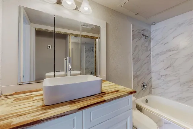 a bathroom with a tub shower and sink