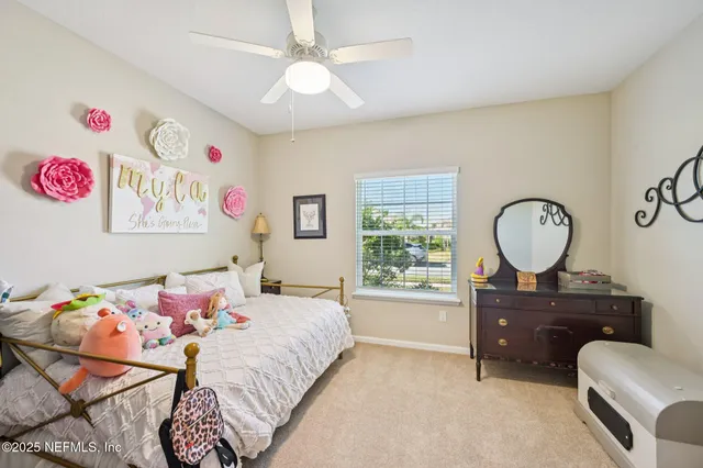 a bedroom with a bed a chandelier and a window