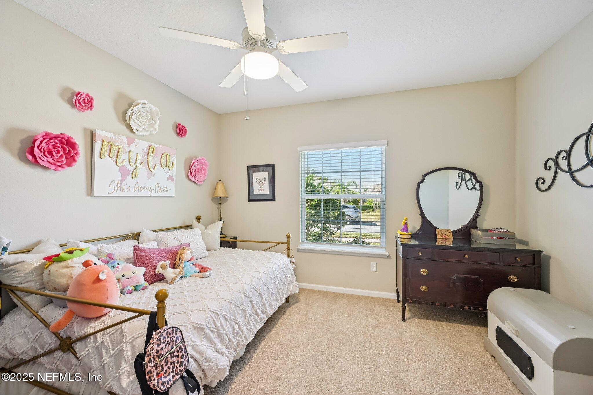 60 Cloverly Point St. Augustine, FL 32092 - Photo 11 of 44 a bedroom with a bed a chandelier and a window