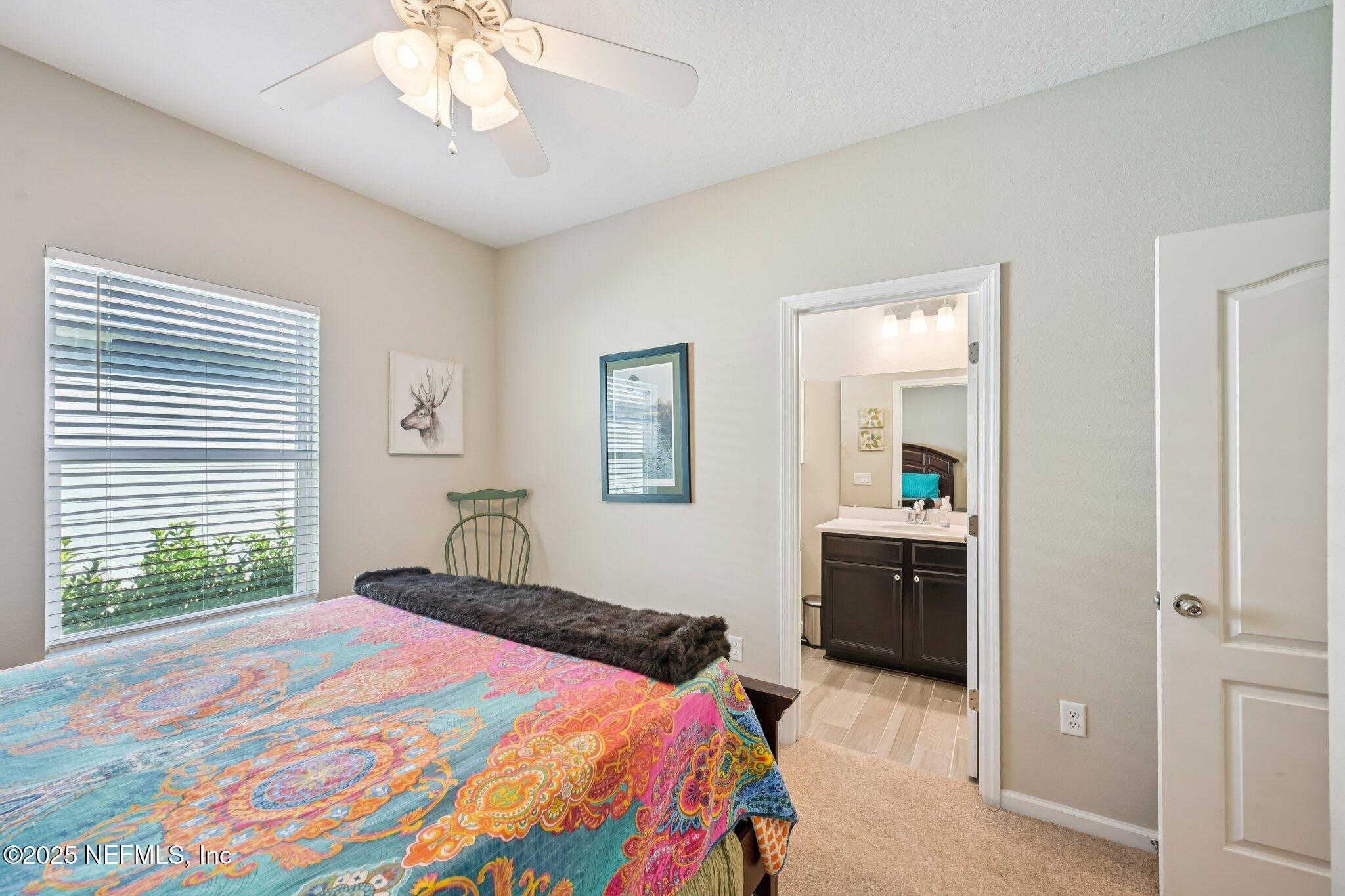 60 Cloverly Point St. Augustine, FL 32092 - Photo 13 of 44 a bedroom with a bed and a chandelier