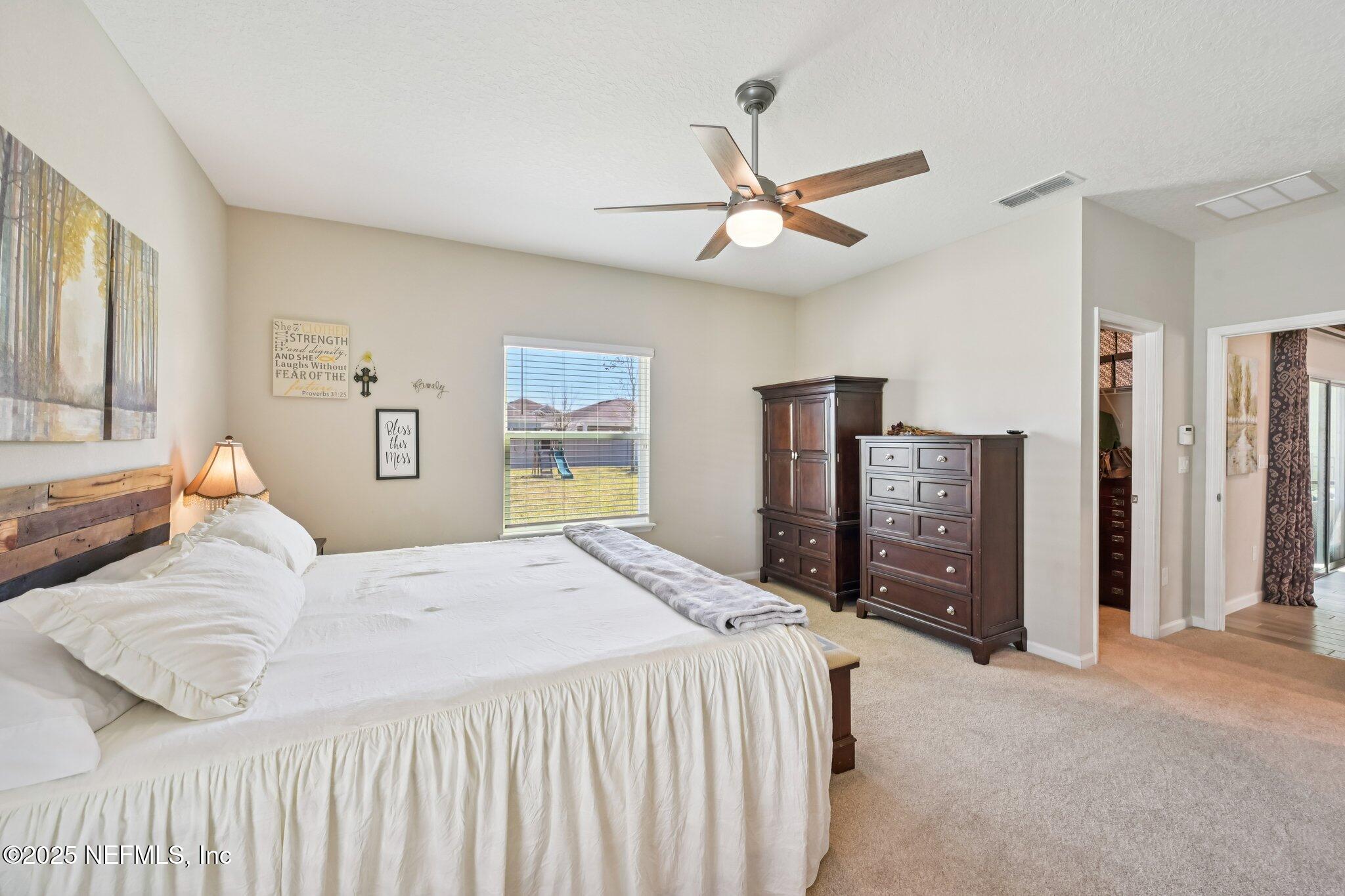 60 Cloverly Point St. Augustine, FL 32092 - Photo 27 of 44 a bedroom with a large bed and a chandelier