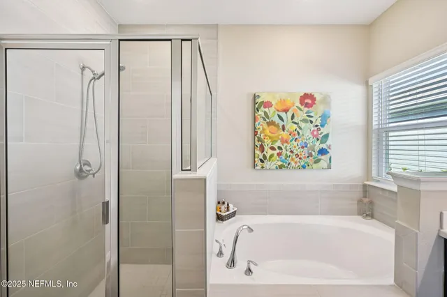 a bathroom with a tub a sink double vanity and a window