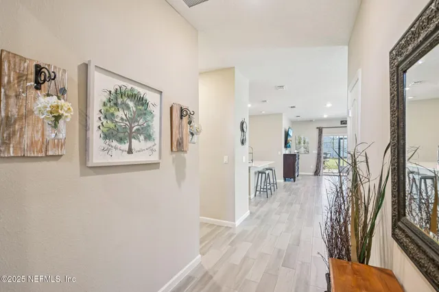 a view of a hallway with wooden floor and a living room