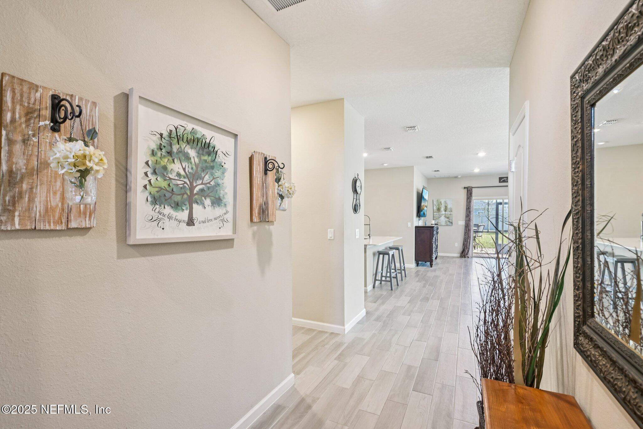 60 Cloverly Point St. Augustine, FL 32092 - Photo 6 of 44 a view of a hallway with wooden floor and a living room