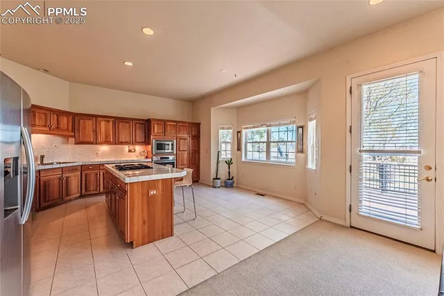 a kitchen with kitchen island granite countertop lots of counter top space and stainless steel appliances