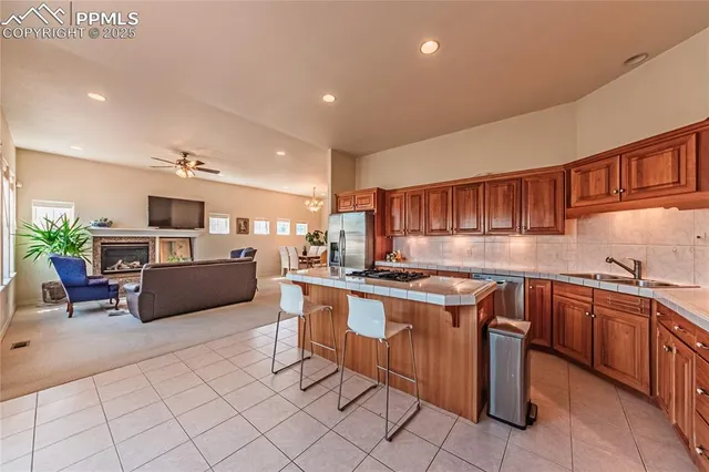 a kitchen with stainless steel appliances granite countertop a stove a sink dishwasher and cabinets with wooden floor