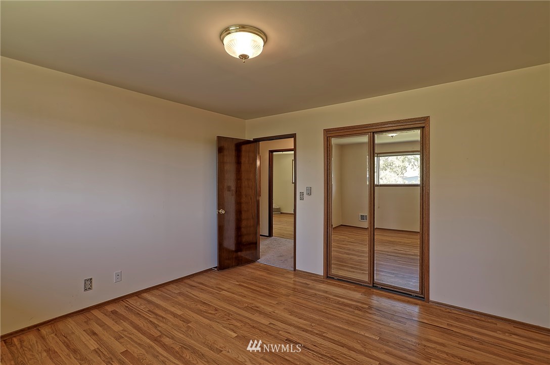 18611 North Road Bothell, WA 98012 - Photo 15 of 38 a view of an empty room with wooden floor and closet