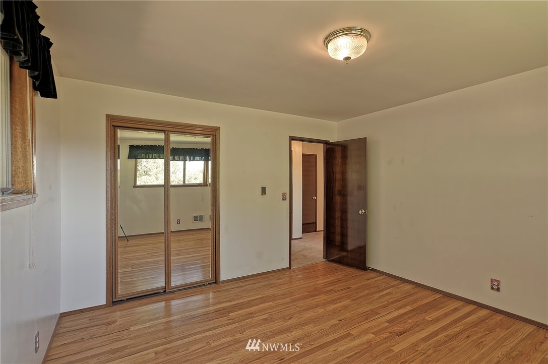 18611 North Road Bothell, WA 98012 - Photo 16 of 38 a view of an empty room with wooden floor and a window