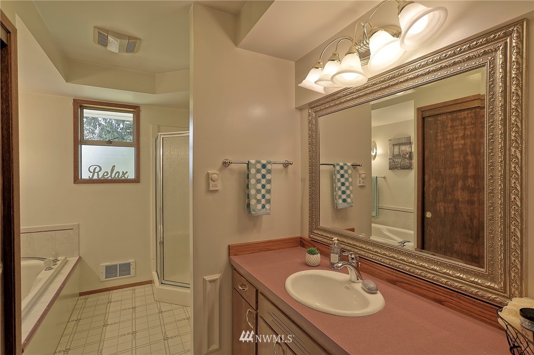 18611 North Road Bothell, WA 98012 - Photo 18 of 38 a bathroom with a sink double vanity granite tub shower and a mirror