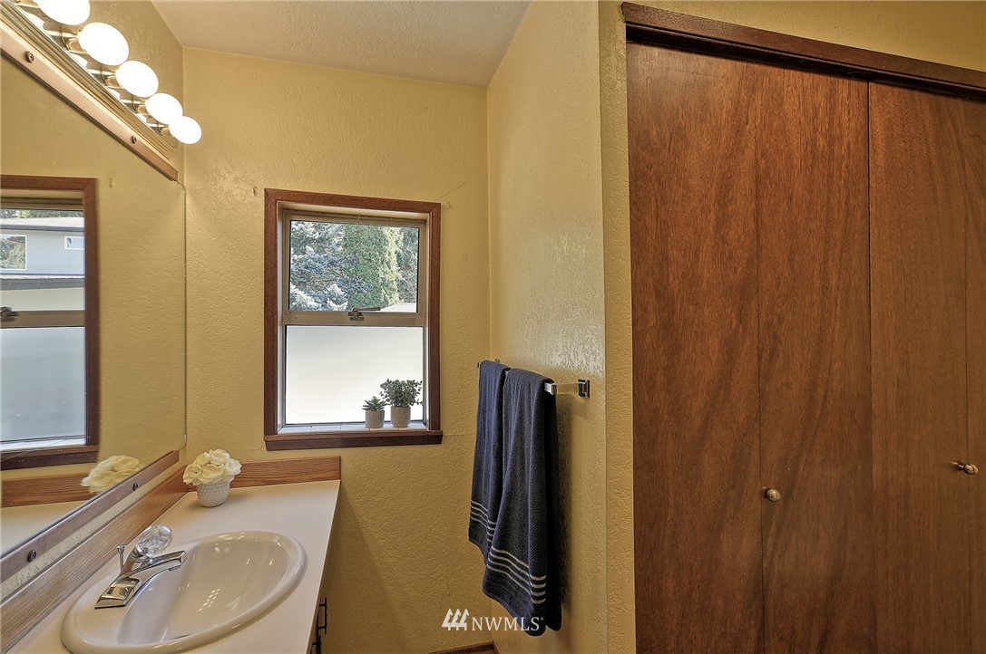 18611 North Road Bothell, WA 98012 - Photo 20 of 38 a bathroom with a granite countertop sink and a mirror