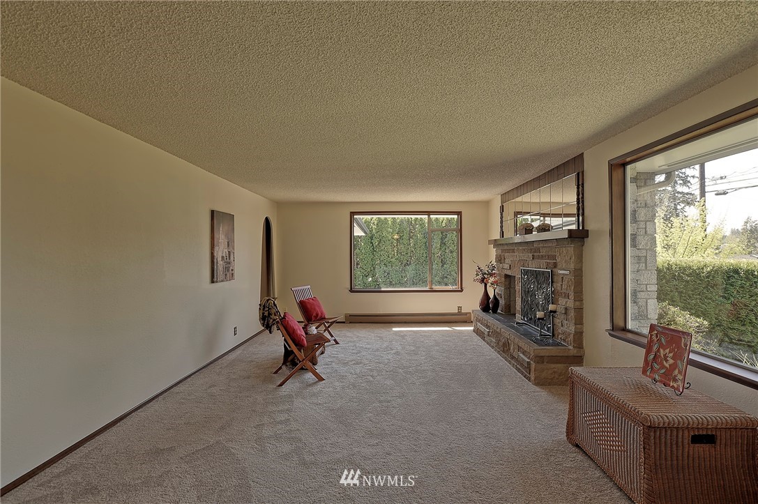 18611 North Road Bothell, WA 98012 - Photo 6 of 38 a living room with furniture large window and a fireplace