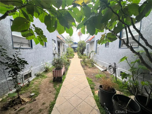 a view of house with a yard and potted plants