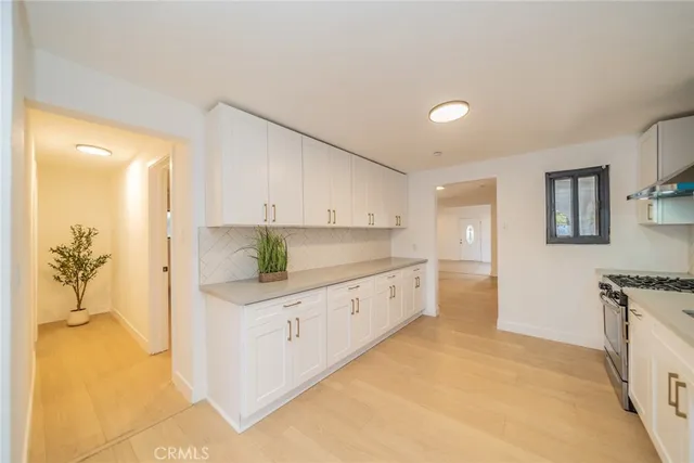 a kitchen with granite countertop a refrigerator and a stove top oven
