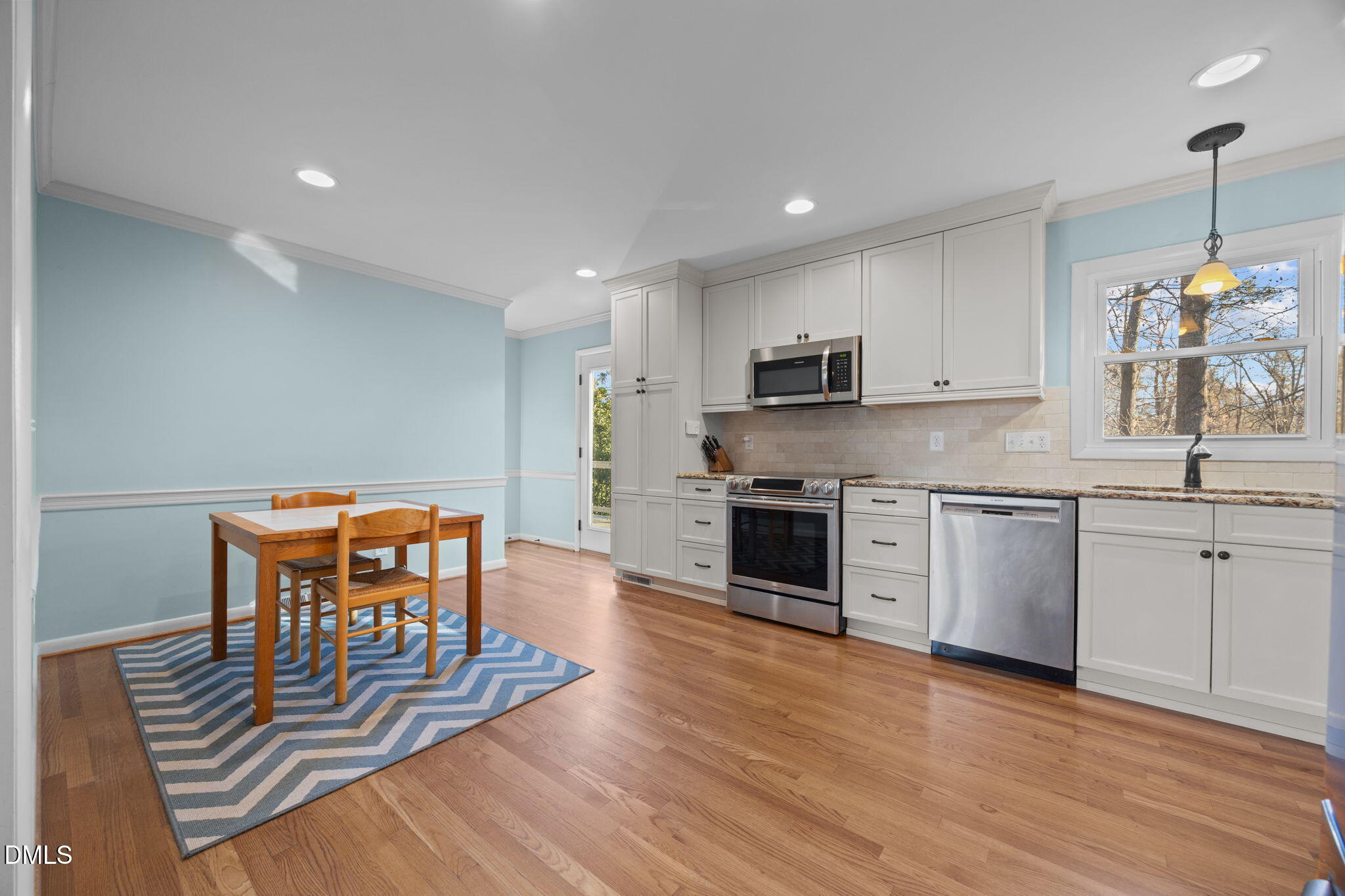 4828 Latimer Road Raleigh, NC 27609 - Photo 6 of 47 a kitchen with stainless steel appliances granite countertop a stove top oven a sink dishwasher a dining table and chairs with wooden floor