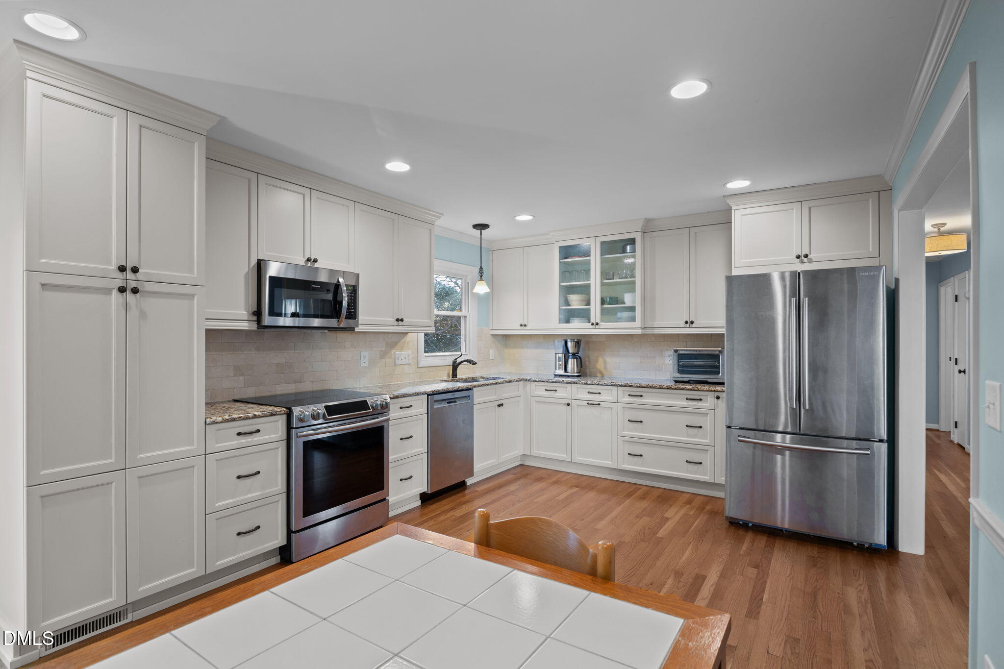4828 Latimer Road Raleigh, NC 27609 - Photo 7 of 47 a kitchen with white cabinets stainless steel appliances and a window