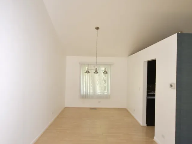a view of an empty room with window and cabinet