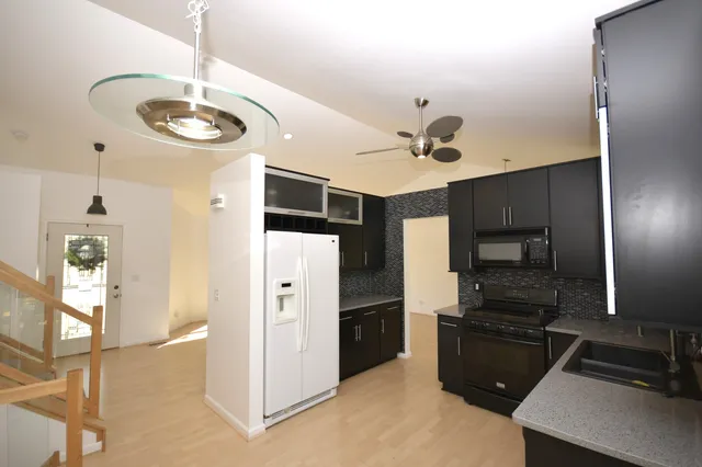 a kitchen with stainless steel appliances a refrigerator and a stove top oven
