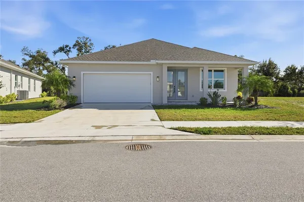 a view of a house with a yard and palm trees