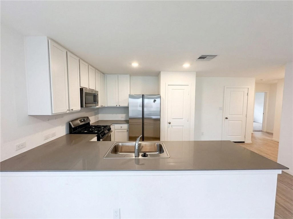 9201 Wilde Way Corpus Christi, TX 78410 - Photo 9 of 21 a view of a kitchen with kitchen island a counter top space a sink wooden floor and a window