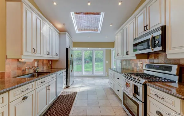 a kitchen with stainless steel appliances granite countertop a stove a sink and a refrigerator