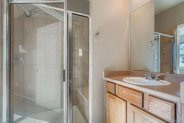a bathroom with a sink vanity granite shower and a mirror