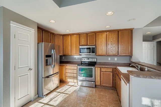 a kitchen with stainless steel appliances granite countertop a refrigerator stove microwave and sink