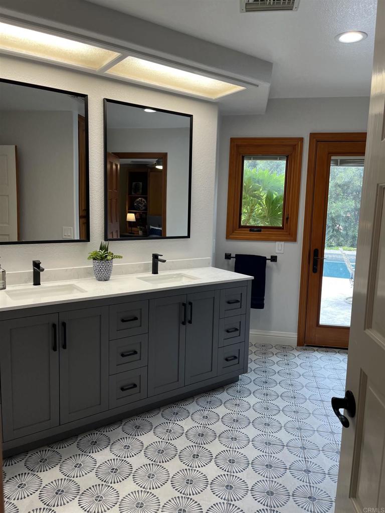 13348 Old Winery Road Poway, CA 92064 - Photo 46 of 68 a bathroom with a double vanity sink large mirror and bathtub