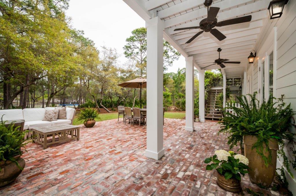 97 Spotted Dolphin Road Santa Rosa Beach, FL 32459 - Photo 25 of 32 a view of a patio with table and chairs potted plants and large tree
