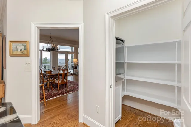 a room with wooden floor and a way to dining table chairs
