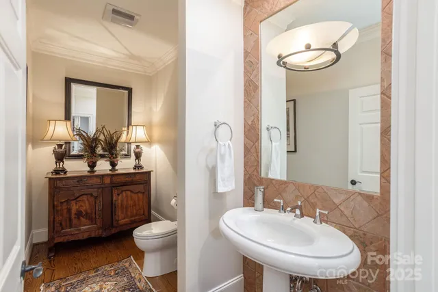 a bathroom with a toilet sink and mirror
