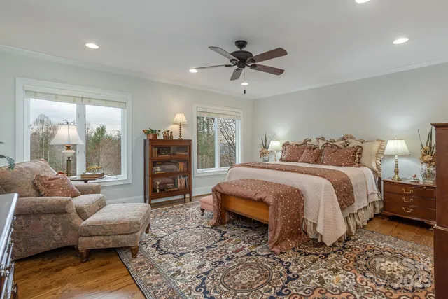 a spacious bedroom with a bed a couch and large window