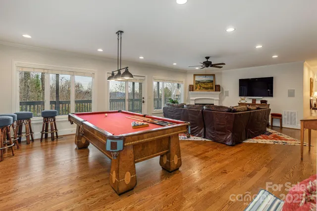 a room with pool table flat screen tv and windows