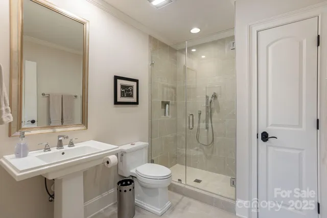 a bathroom with a shower sink mirror and toilet