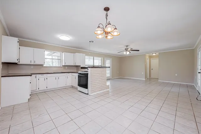 a large white kitchen with cabinets
