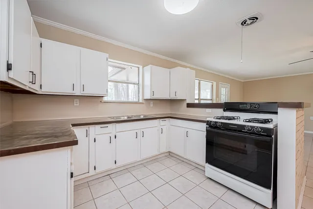 a kitchen with granite countertop white cabinets and stainless steel appliances