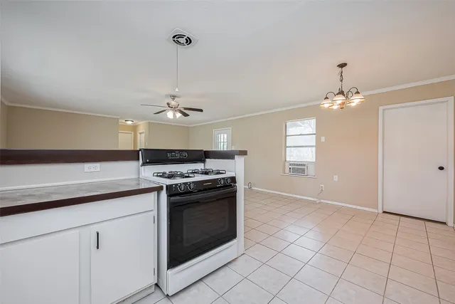a kitchen with kitchen island granite countertop a stove a sink and a refrigerator