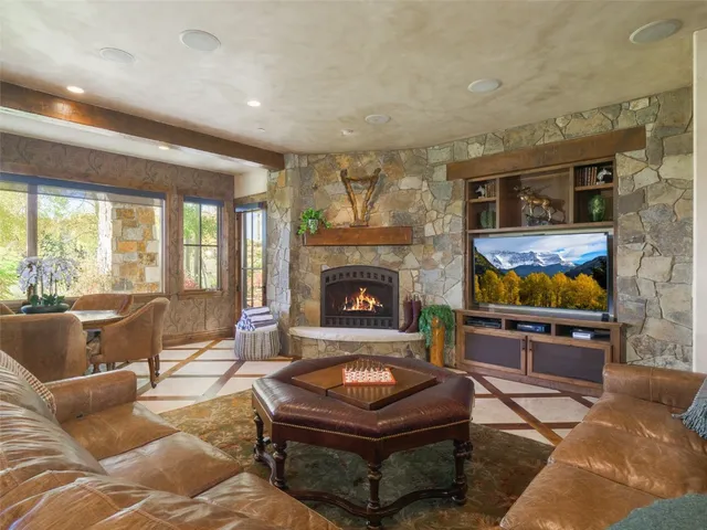a living room with furniture a chandelier and a fireplace