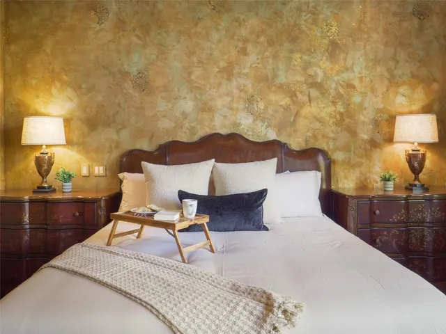 a bedroom with a large bed and a chandelier