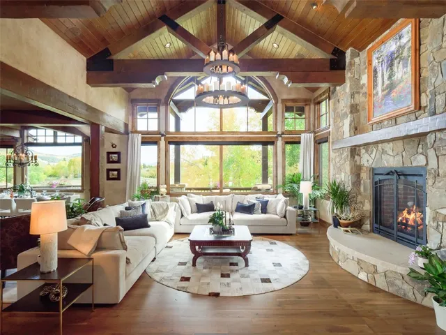 a living room with furniture a chandelier and a large window