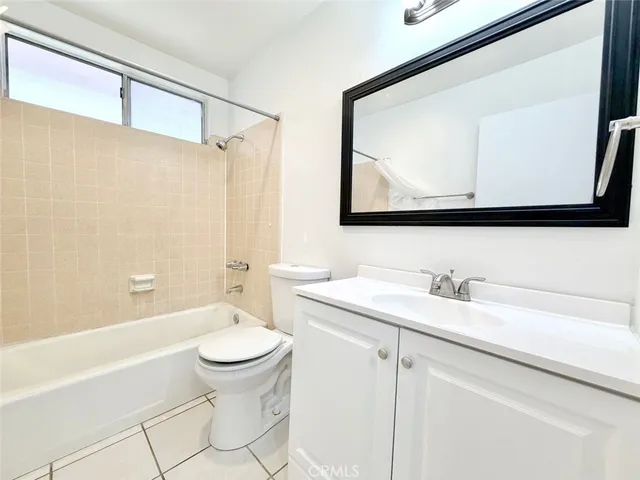 a bathroom with a granite countertop sink mirror vanity and toilet