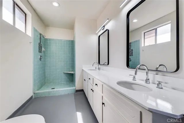 a bathroom with a double vanity sink mirror and shower