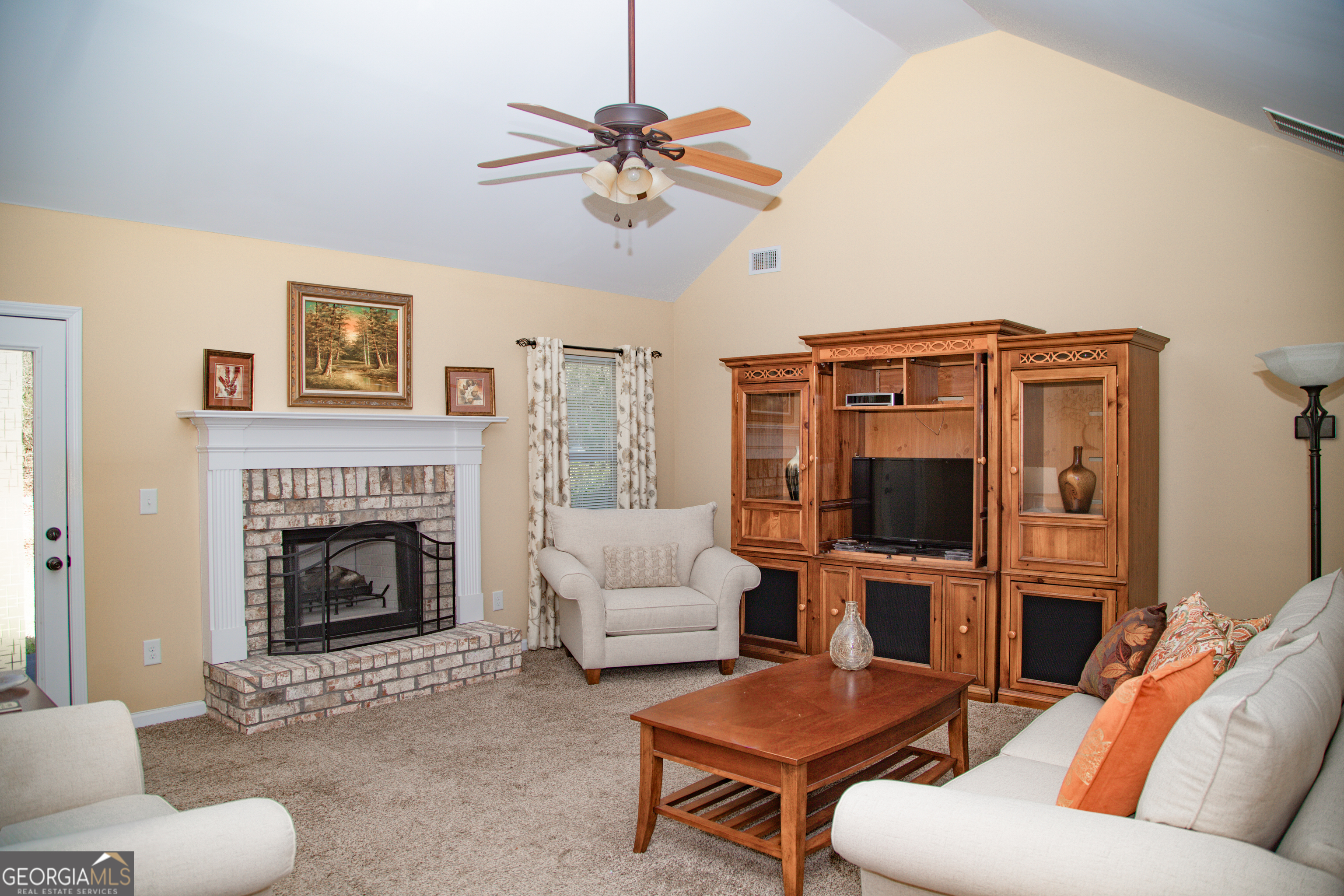 149 Bridle Path Griffin, GA 30224 - Photo 13 of 47 a living room with furniture a fireplace and a flat screen tv