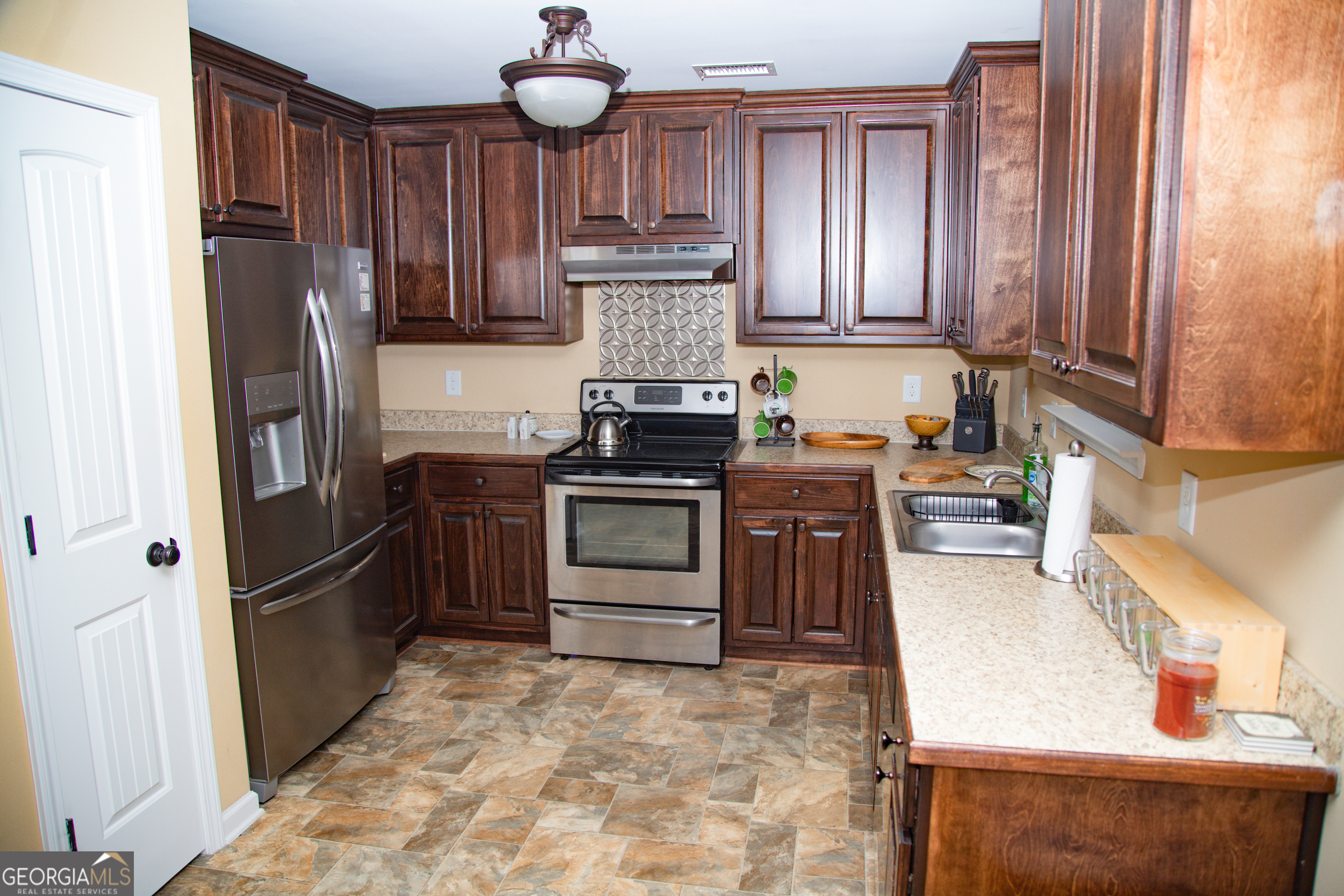 149 Bridle Path Griffin, GA 30224 - Photo 24 of 47 a kitchen with stainless steel appliances granite countertop a stove refrigerator and cabinets