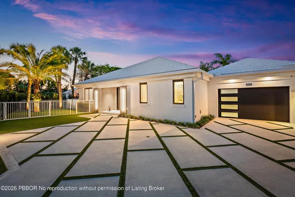 a view of a patio with table and chairs potted plants and floor to ceiling window