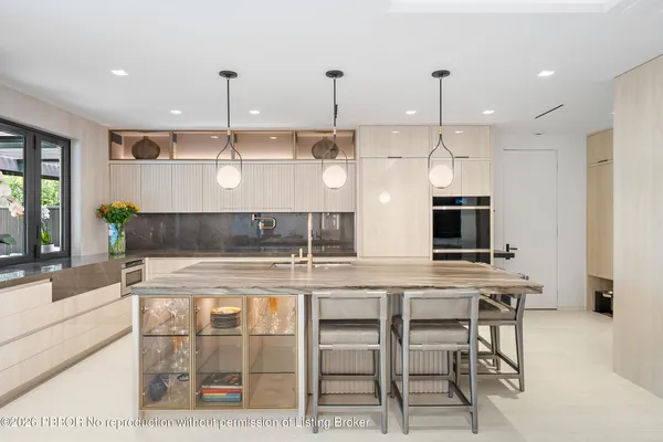 a kitchen with stainless steel appliances granite countertop a stove a refrigerator a oven a kitchen island a dining table and chairs