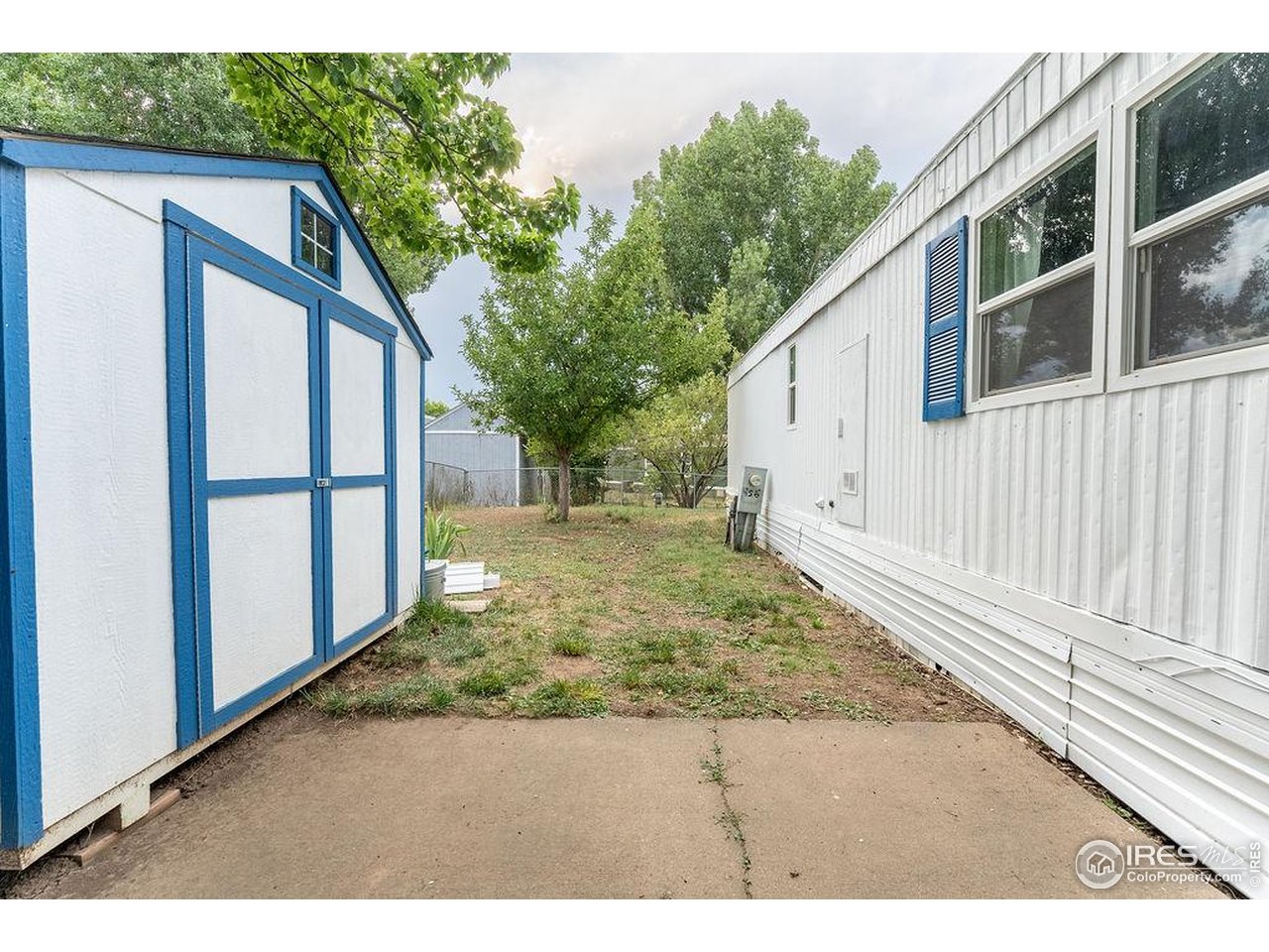 2500 East Harmony Road, Unit 456 Fort Collins, CO 80528 - Photo 15 of 22 a view of backyard with large trees and wooden fence