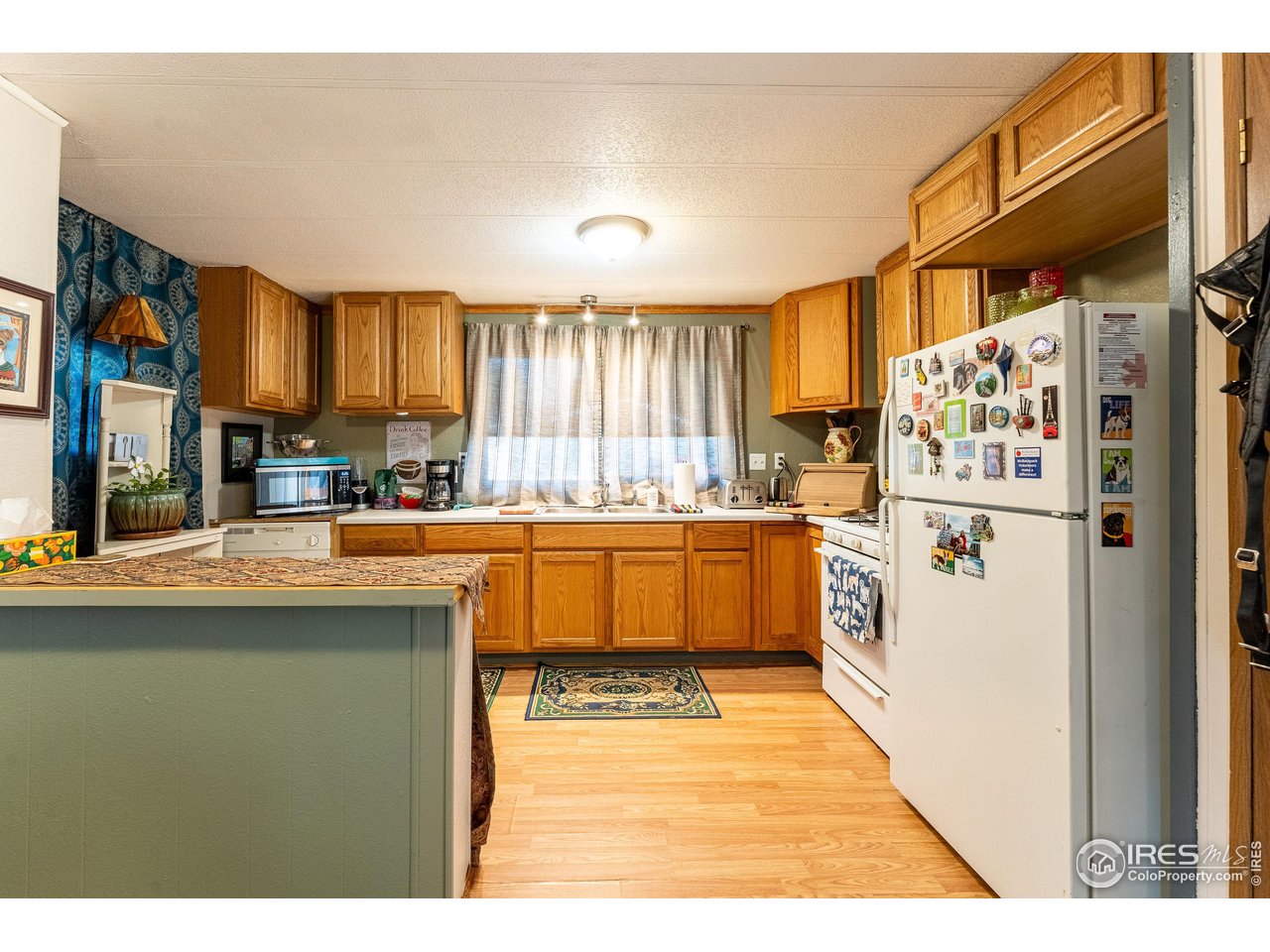 2500 East Harmony Road, Unit 456 Fort Collins, CO 80528 - Photo 4 of 22 a kitchen with granite countertop a refrigerator and a sink