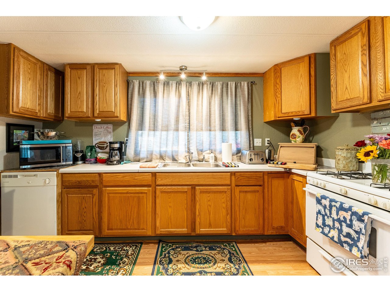 2500 East Harmony Road, Unit 456 Fort Collins, CO 80528 - Photo 6 of 22 a kitchen with stainless steel appliances granite countertop a refrigerator a sink dishwasher a stove with wooden cabinets and floor