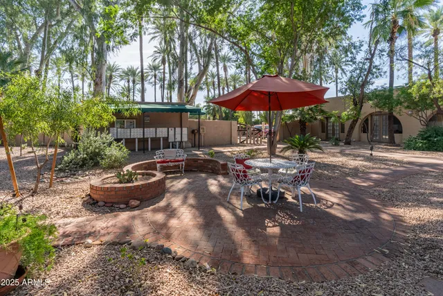 a view of a patio with table and chairs under an umbrella