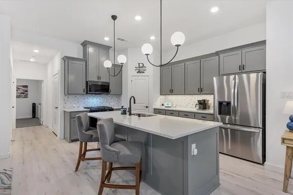 a kitchen with a center island a counter space appliances and cabinets